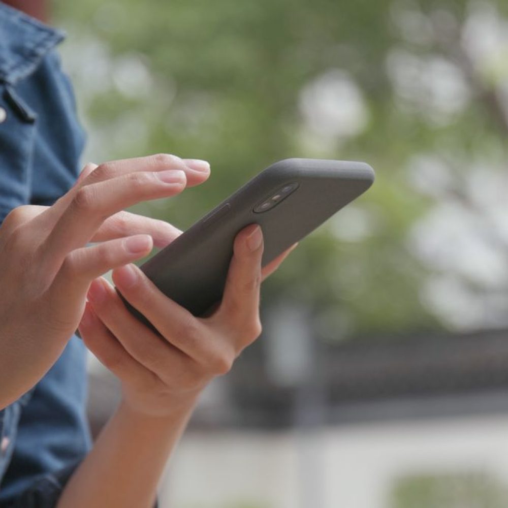 close-up-of-woman-sending-sms-on-cellphone-in-chin-2021-08-29-07-40-11-utc